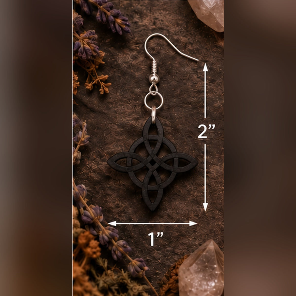 Black Celtic knot dangle earring with silver hook displayed on a rustic botanical background, measuring 2 inches in total drop length and 1 inch wide.