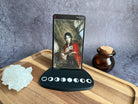 Tarot card holder with a card in it with character illustration all on a wooden surface